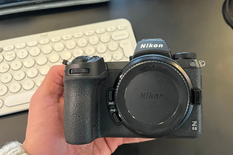 fotograf drzi fotoaparat pri prirodzenom svetle pocas fotenia v meste